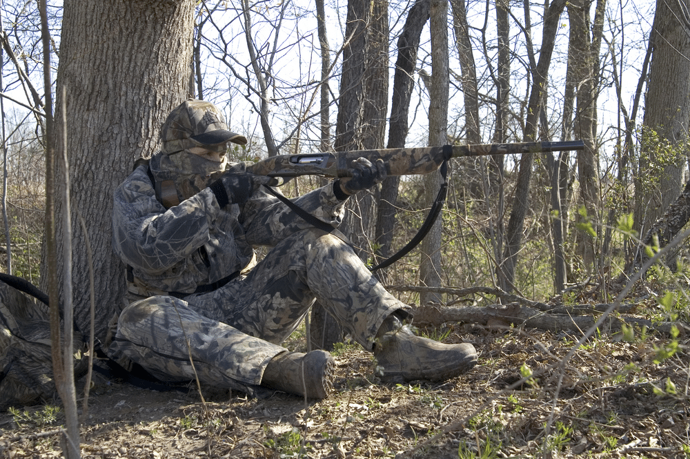 a hunter aiming with a gun