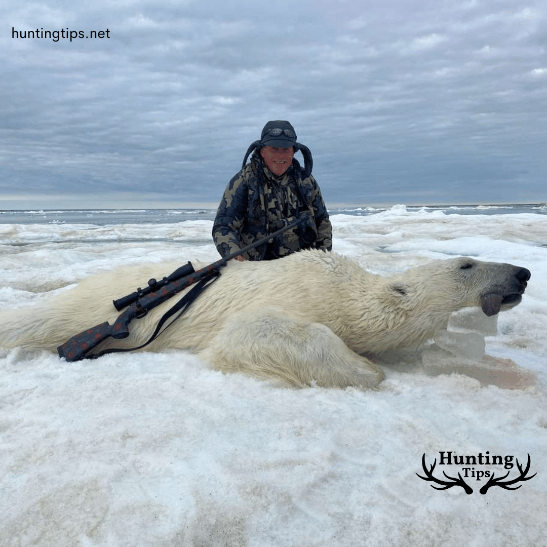 a hunter with a hunted polar bear