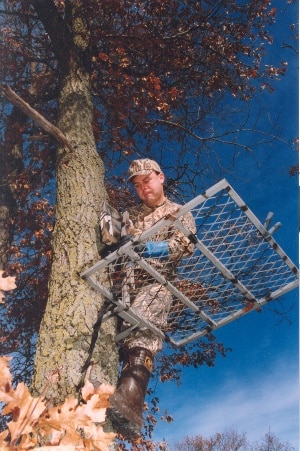 A hunter seen on a tree stand placed high