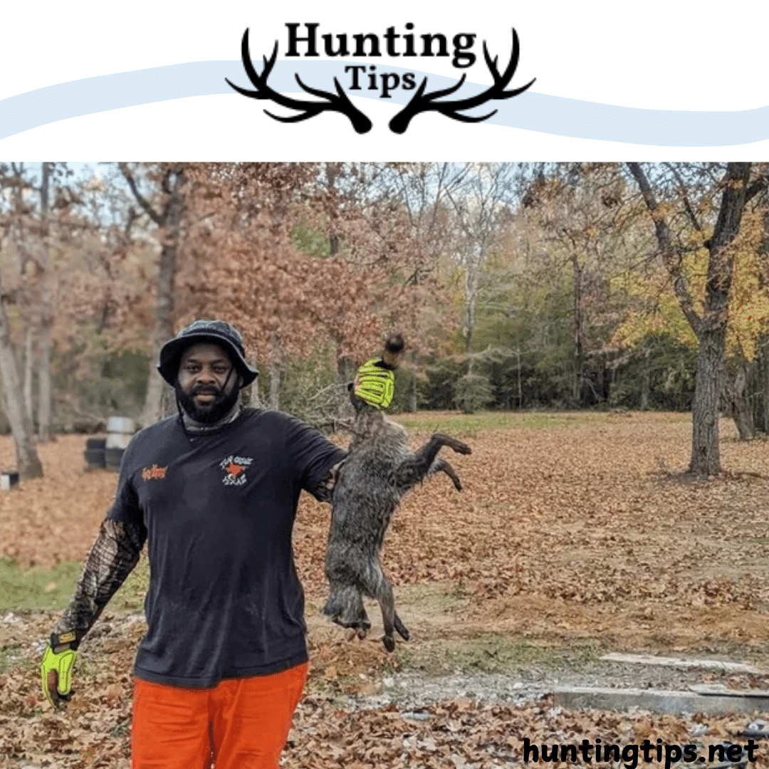 a man holding a hunted coon in his hand