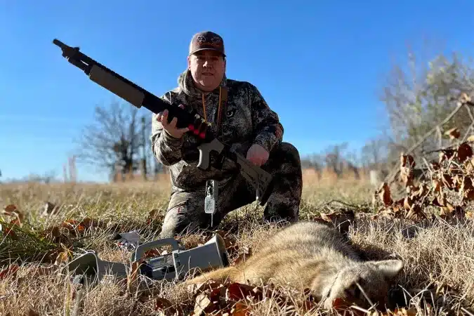 a hunter with hunted dead coyote