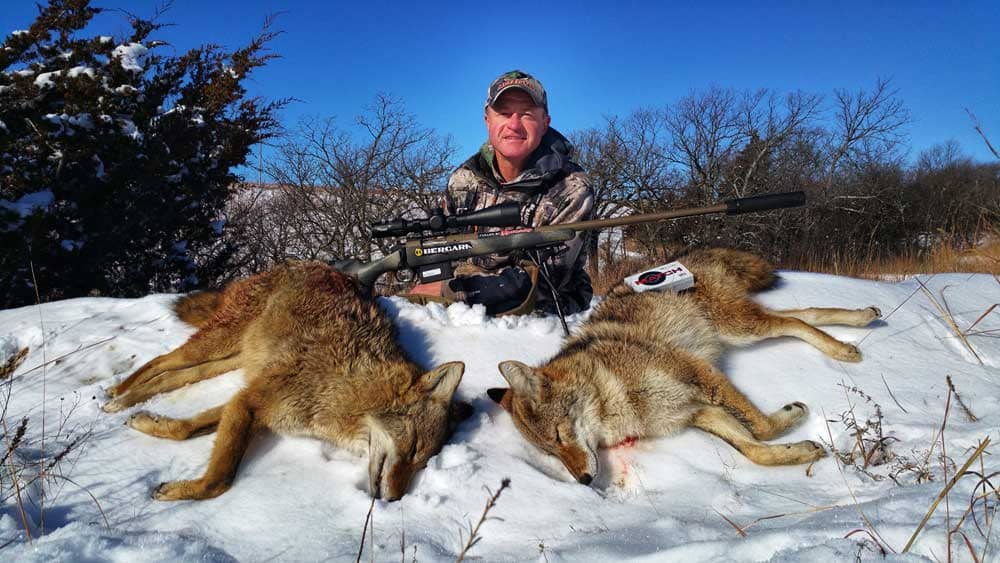 a hunter with hunted snow coyotes