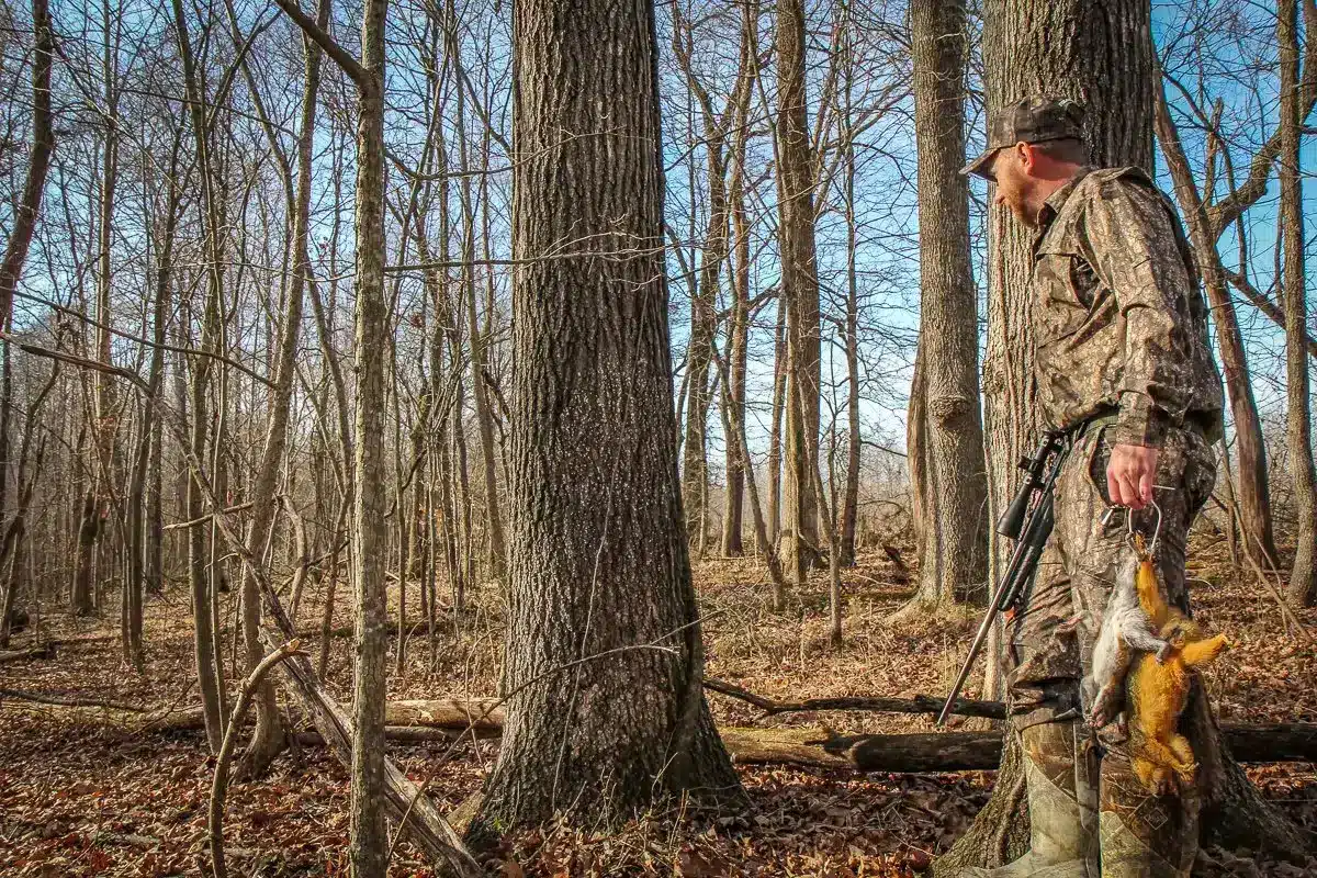 a hunter with hunted squirrels in the woods