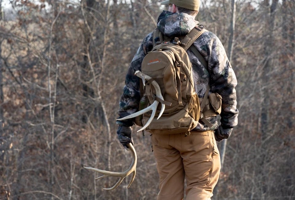 a person having sheds in his bag walking in woody jugles