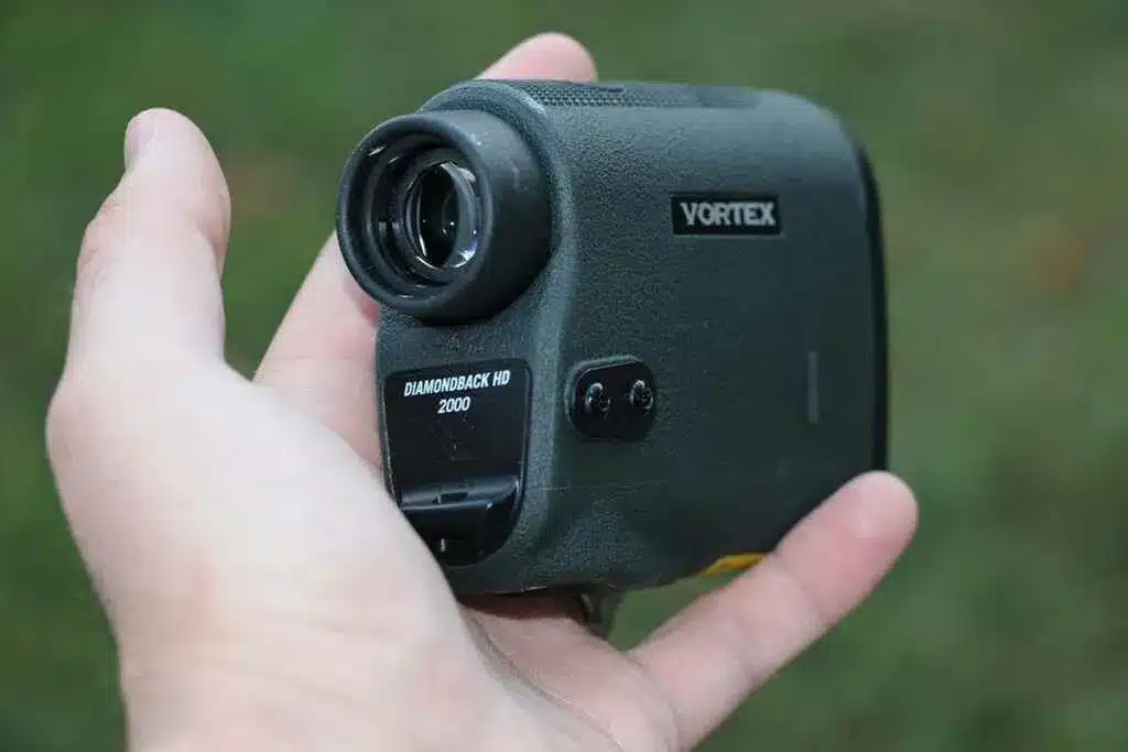 a person is holding the vortex rangefinder in hand