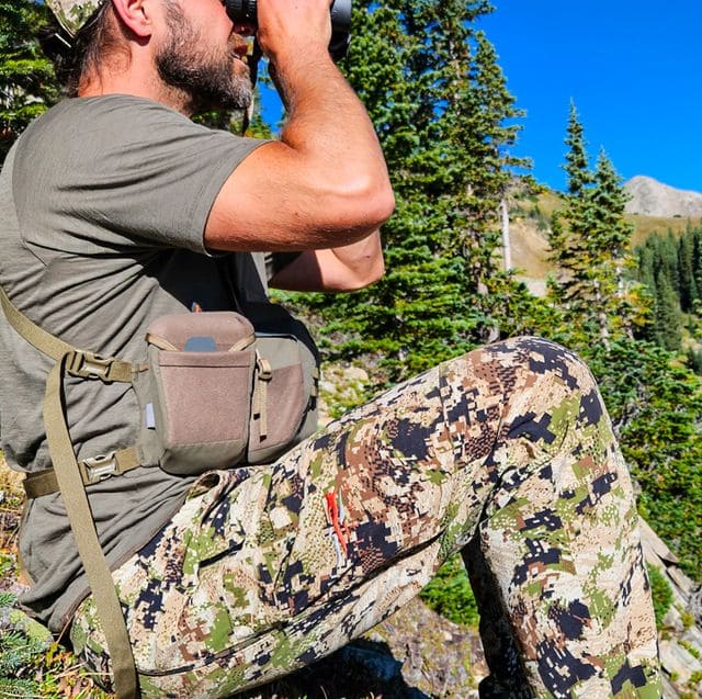 pop hunting pants wear by a hunter and binoculars in his hands