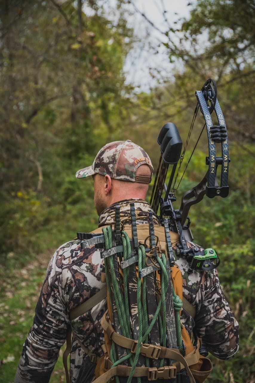 a man is having a seddle hunting kit on his back